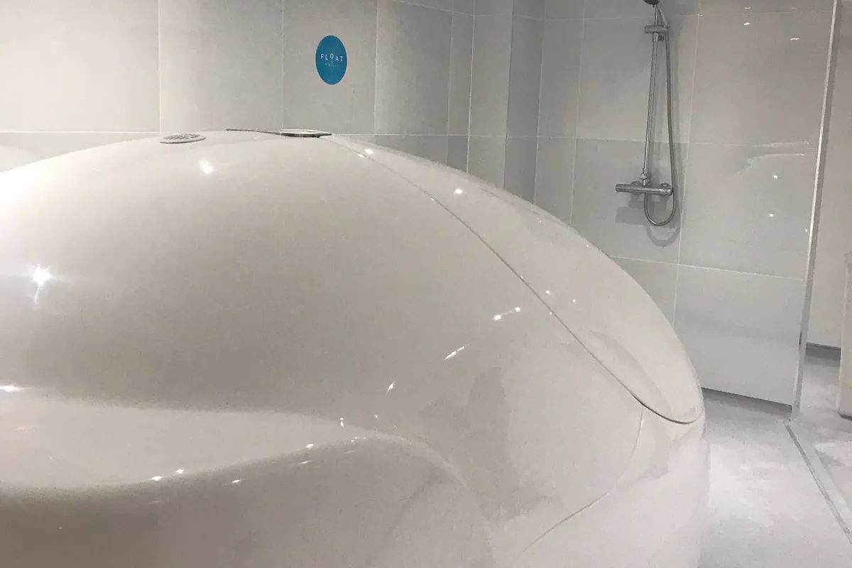 A white float pod open in a bright float room