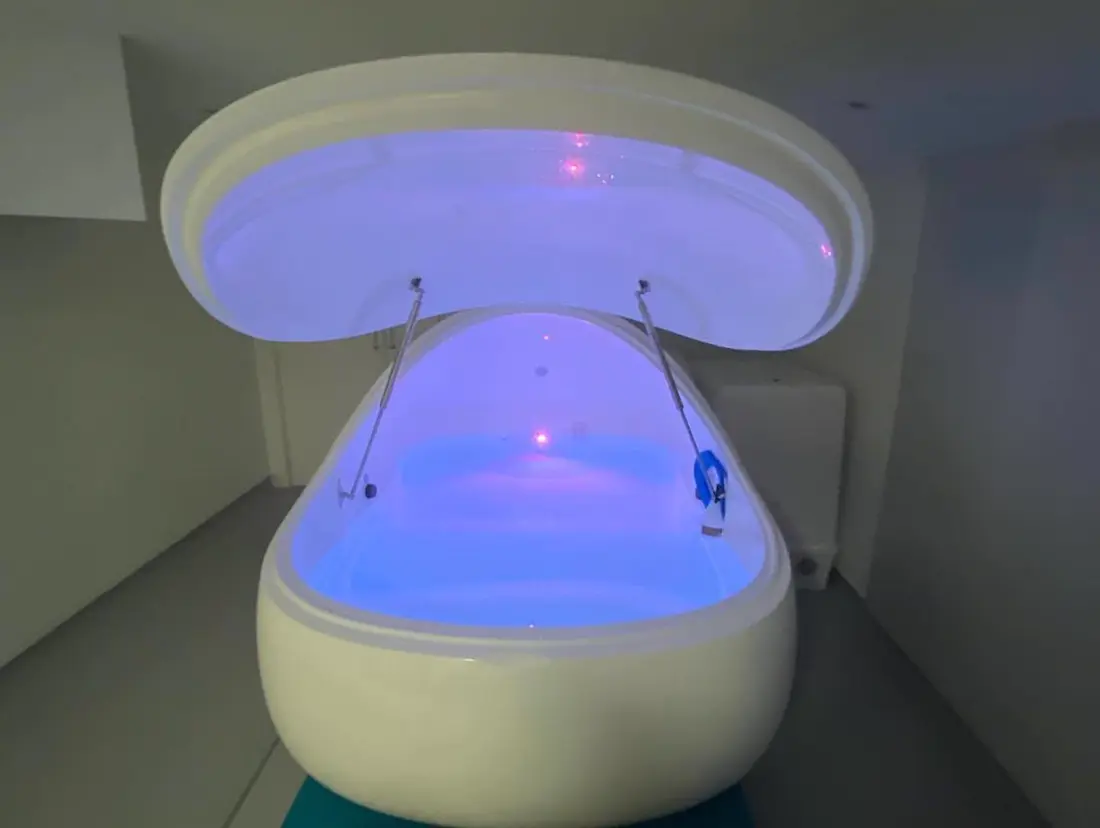 A float pod with its lid raised and the water lit blue.